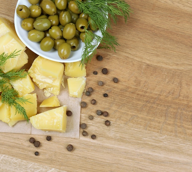 Parmigiano reggiano erbe aromatiche e olive su fondo di legno