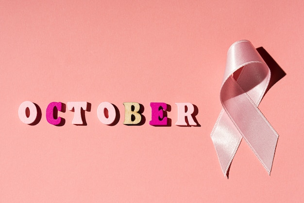 Parola di ottobre e nastro rosa su sfondo rosa