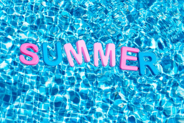 Parola estate a colori che galleggia su uno spazio di copia in piscina