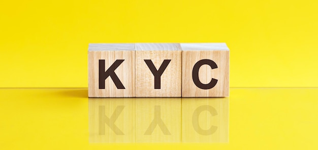 Parola KYC scritta sul blocco di legno. la parola cif è fatta di blocchi di legno che giacciono sul tavolo giallo, concetto di business. KYC abbreviazione di conosci il tuo cliente