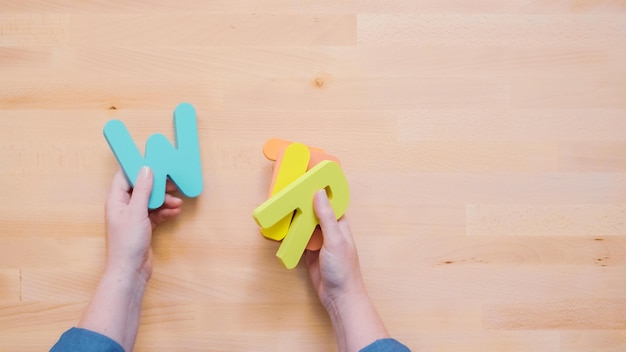 Parola SCRIVERE da lettere di legno multicolori su tavola di legno.