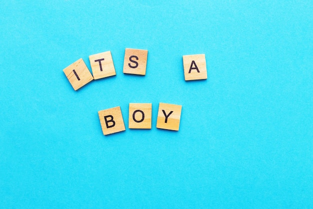 Parola È un ragazzo di cubi di legno su sfondo blu Simbolo del concetto di nascita della genitorialità del parto