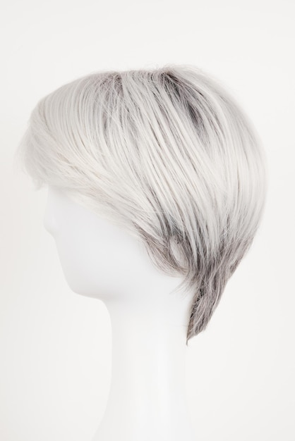 Parrucca bionda d'aspetto argento naturale su testa di manichino bianco capelli corti sul portatore di parrucca di plastica isolato su sfondo bianco vista laterale