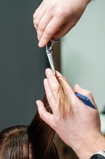 Parrucchiere che taglia i capelli della donna.