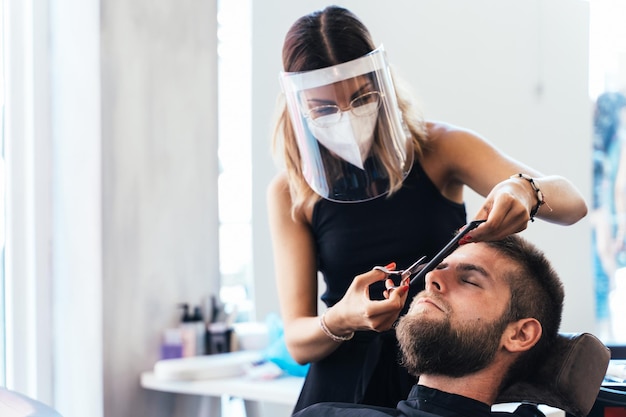 Parrucchiere che taglia i capelli di un cliente in un salone