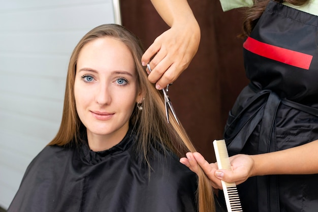 Parrucchiere che taglia i capelli nel salone di bellezza