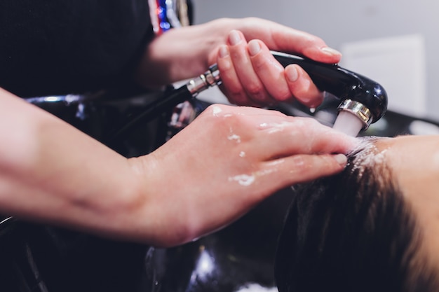 Parrucchiere lavaggio capelli donna con shampoo.