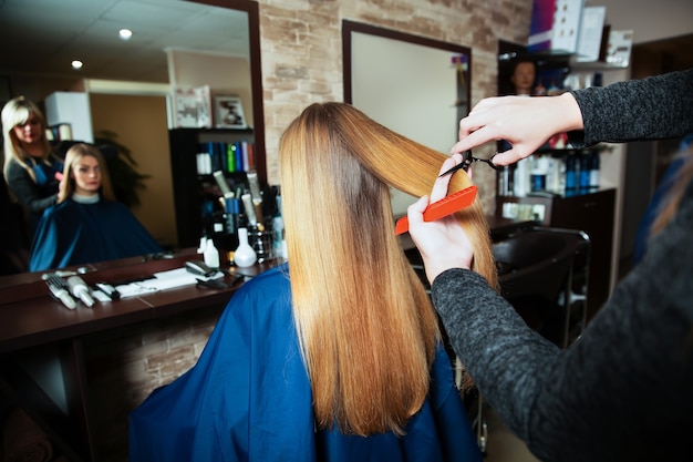 Parrucchiere professionista che taglia i capelli con le forbici