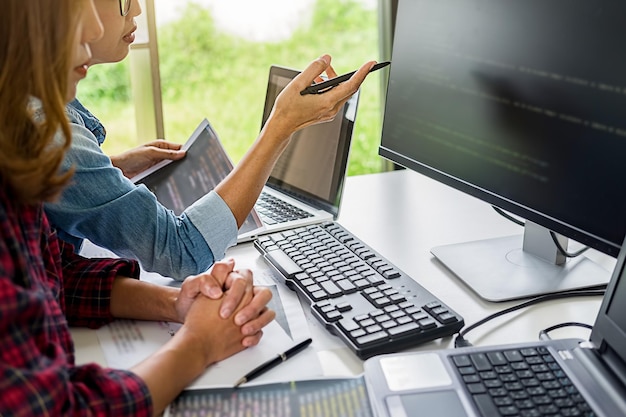 Parte centrale di colleghi che discutono dati sul computer sulla scrivania in ufficio