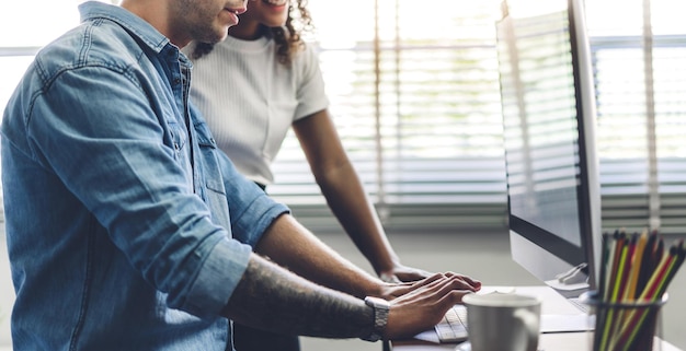 Parte centrale di uomini d'affari che discutono al computer in ufficio