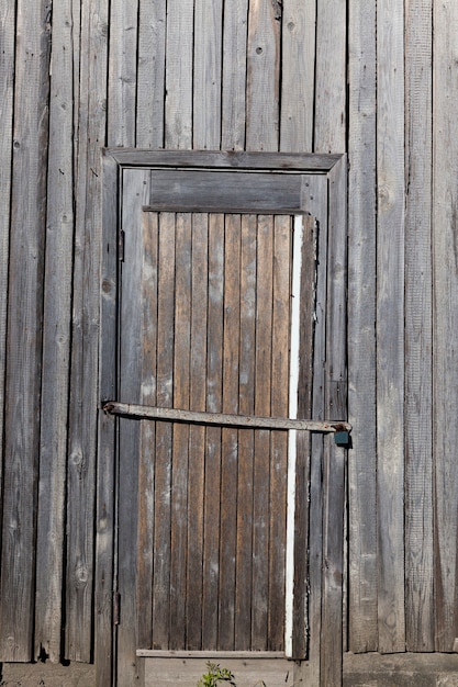 Parte del vecchio muro in legno dell'edificio, con porta a battente chiusa, particolari di costruzione rustica