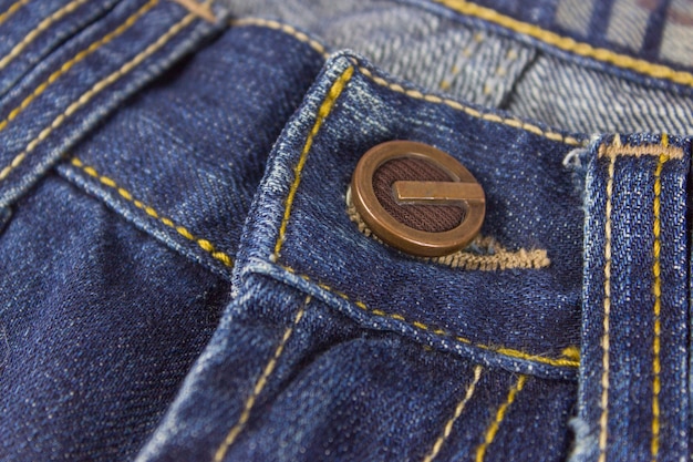 Parte di jeans con rivetto in metallo, cuciture e impunture. Abbigliamento, concetti di negozio online.