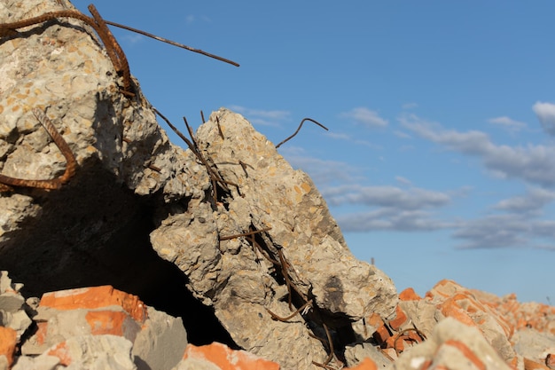 Parte di un muro di mattoni distrutto con frammenti di raccordi in ferro