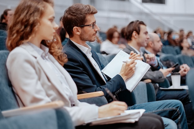 Partecipanti al seminario aziendale che prendono appunti sui loro quaderni