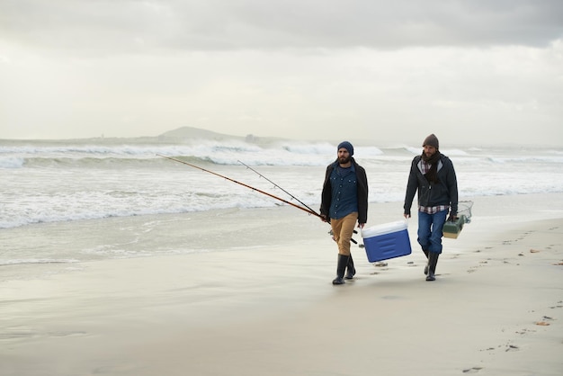 Partendo per una giornata di pesca Inquadratura di due amici che pescano in una mattina presto nuvolosa