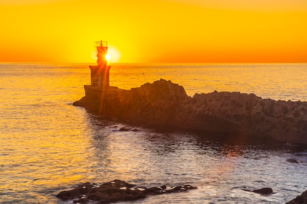 Particolare del sole dietro il faro al tramonto nella città di Pasajes San Juan