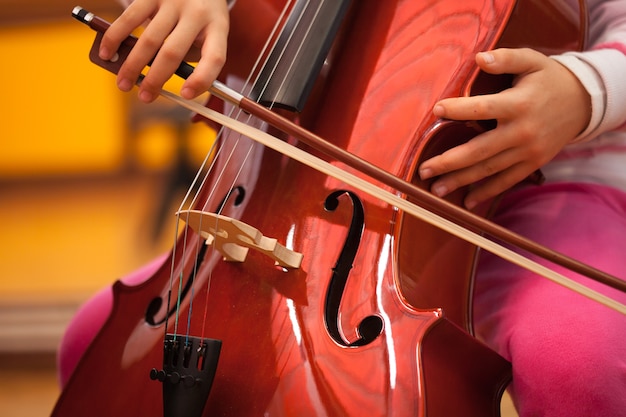 Particolare di un bambino che suona il violoncello