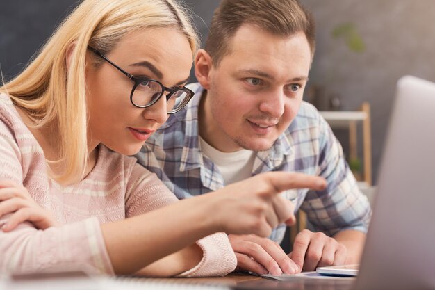 Partner commerciali seri che lavorano in un ufficio moderno. Due colleghi concentrati che discutono di un nuovo progetto mentre lavorano al laptop, copia spazio