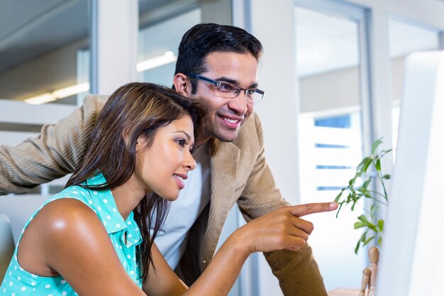 Partner sorridenti che lavorano insieme sul computer