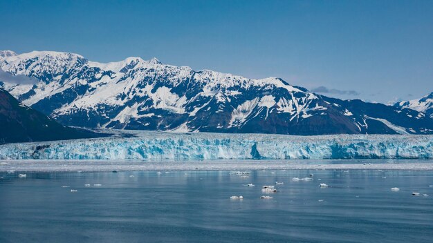 Parto del ghiacciaio di montagna e ghiaccio nell'acqua dell'oceano di mare sotto la natura del cielo blu Natura del ghiacciaio Hubbard