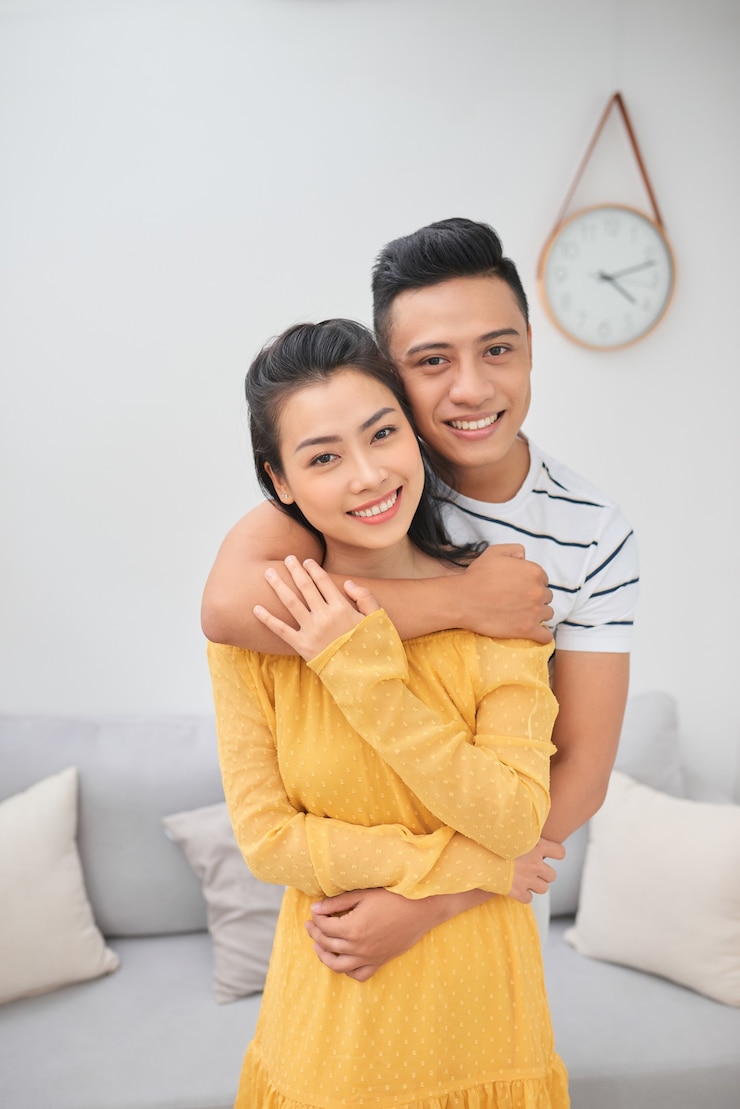 Photo pasangan muda romantis berpelukan di ruang tamu