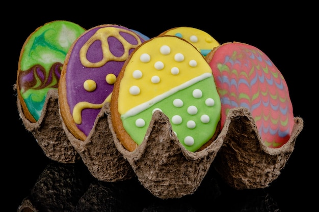 Pasqua decorate uova al forno, biscotti su uno sfondo nero.