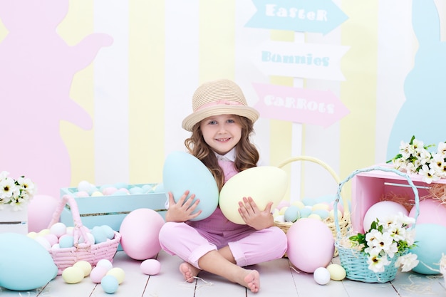 Pasqua! la ragazza tiene grandi uova colorate nelle sue mani all'interno di Pasqua. Un bambino carino sta inseguendo le uova di Pasqua. Decorazione pasquale. Bambino e giardino. Piccolo contadino. Raccolta