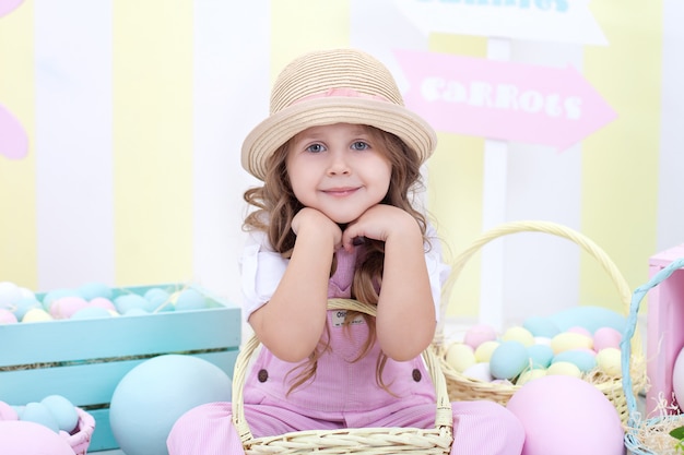 Pasqua! la ragazza tiene un cesto di uova all'interno di Pasqua. Decorazioni colorate di Pasqua. Ragazza che insegue le uova di Pasqua. decorazione primaverile, festa di famiglia, agricoltura. Bambino e giardino. Raccolta