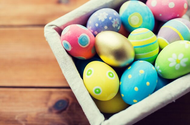 Pasqua, vacanze, tradizione e concetto di oggetto - primo piano di uova di Pasqua colorate nel cesto