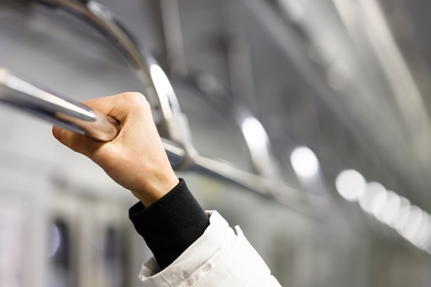 Passanger che tiene il corrimano in metropolitana, fuoco molle a disposizione.