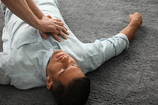 Passante che esegue la rianimazione cardiopolmonare su un uomo incosciente al chiuso Pronto soccorso