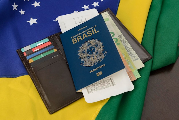 Passaporto brasiliano sul tavolo con bandiera brasiliana sullo sfondo