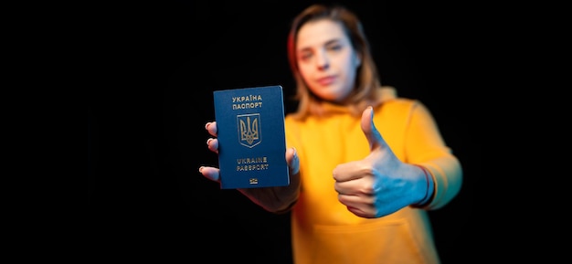 Passaporto nazionale ucraino Bella ragazza ucraina con passaporto governativo in mano su sfondo nero