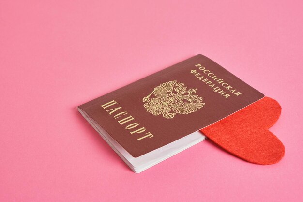 Passaporto russo e cuore in feltro rosso su sfondo rosa amore per la madrepatria