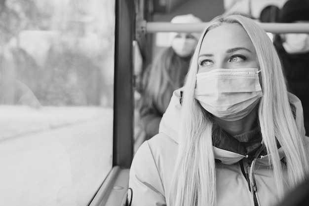 Passeggeri seduti su un autobus che si proteggono dalla pandemia globale indossando maschere mediche