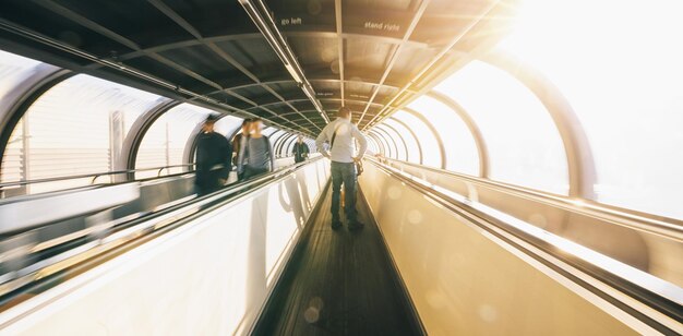 Passeggero che corre attraverso una scala mobile nel terminal dell'aeroporto