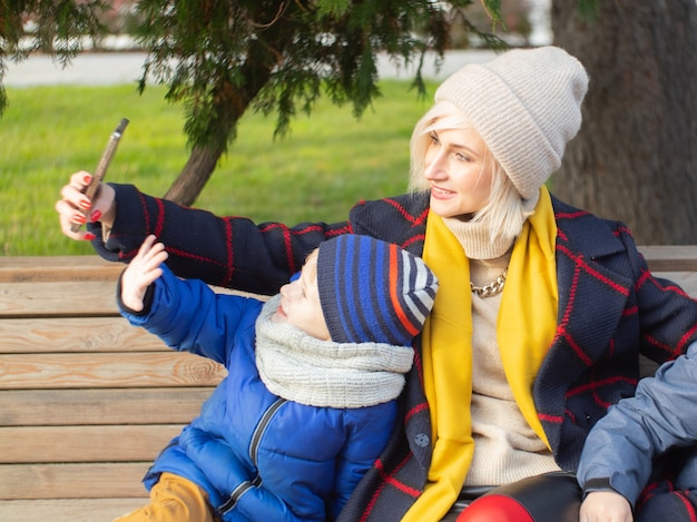 Passeggiata autunnale. Mamma e figlio parlano in videocomunicazione