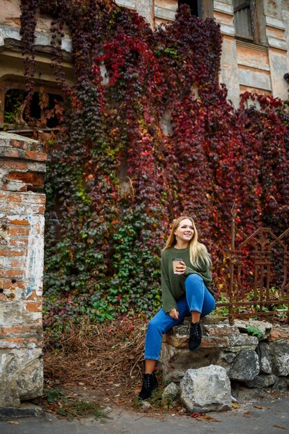 Passeggiata di una bella ragazza in maglione e jeans