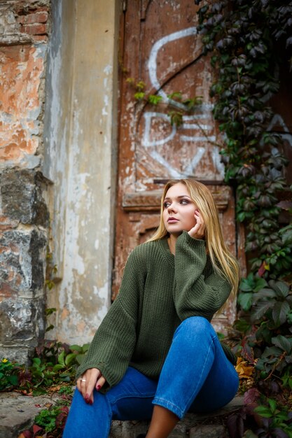 Passeggiata di una bella ragazza in maglione e jeans