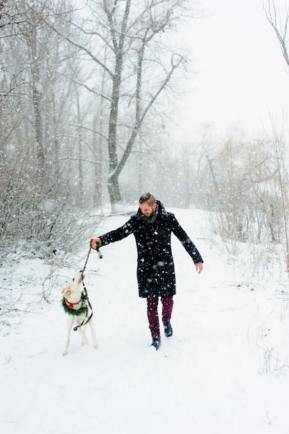 Passeggiata invernale in una tempesta di neve con un cane