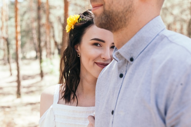 Passeggiata nuziale in pineta. Giorno soleggiato. Sposi nella foresta. Bella sposa e sposo in una passeggiata. Abito da sposa bianco. Bouquet di peonie e ortensie.