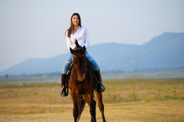 Passeggiate a cavallo da dietro con vista su campi e montagne spalancati