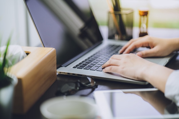 Passi i piani di lavoro di vendita con il computer portatile in ufficio