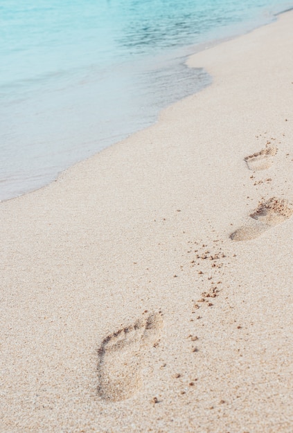 Passi in sabbia sulla fuga tropicale di estate