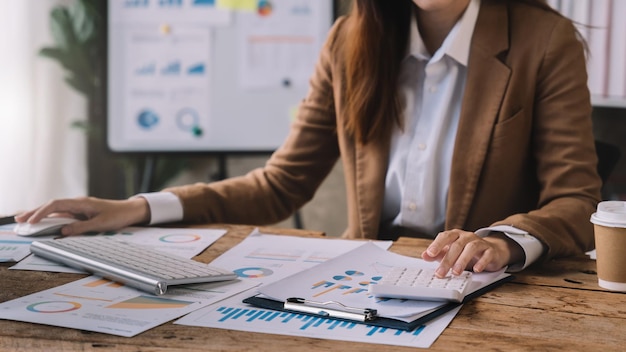 Passi la donna di affari che fa le finanze e calcoli sulla scrivania circa il costo all'ufficio