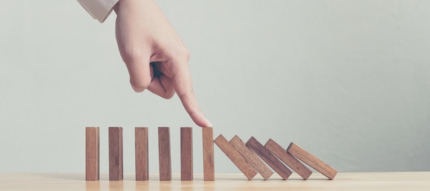 Passi la fermata dell'effetto di crisi economica di legno di domino o il concetto di protezione del rischio