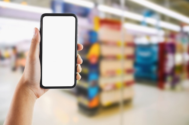 Passi la tenuta dello schermo bianco mobile sul deposito del supermercato