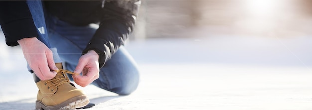 Passi lungo il sentiero innevato. Un uomo cammina nel parco in inverno.