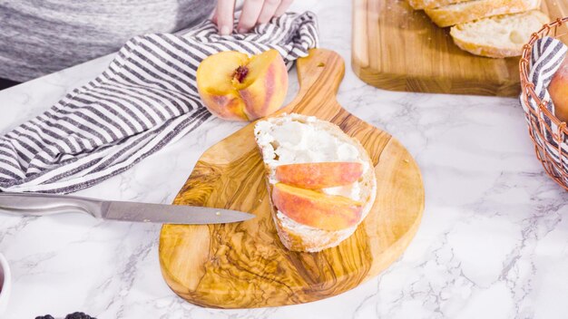 Passo dopo passo. Affettare la pesca biologica per fare un toast di ricotta e pesca su ciabatta.