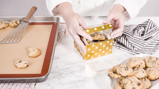 Passo dopo passo. Confezionamento di biscotti con gocce di cioccolato fatti in casa in una piccola confezione regalo.